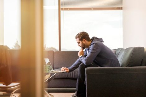 man working home computer hotel room stock photo